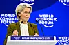 Ursula von der Leyen taler ved WEFs årsmøte 2026 foran blå bakvegg med logoer.