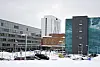 Vinterbilde av Universitetssykehuset i Nord-Norge med snødekt parkeringsplass.