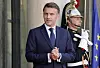 Emmanuel Macron står foran Élysée-palasset med en vakt fra republikanergarden bak seg.
