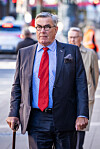 Stein Erik Hagen går mot kamera på fortauet utenfor Norges Bank i Oslo.