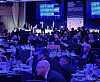 Secret Service agents near a stage while guests are seated at tables at the White House Correspondents' Dinner.