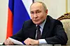 Vladimir Putin sitter ved et bord under et videomøt i Kreml, med russisk flagg i bakgrunnen.