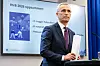 Jens Stoltenberg står ved en talerstol foran en skjerm med budsjettpresentasjon i Oslo.