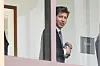 Sam Altman står i en korridor ved en føderal domstol og ser mot kameraet.