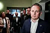 Riksmekler Mats Wilhelm Ruland står foran pressen i en korridor, med flere personer bak.