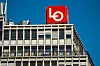 Rødt LO-skilt på toppen av Folkets hus i Oslo mot blå himmel.