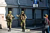 To bevæpnede soldater står i en gate i Oslo mens en forbipasserende ser på under en feltøvelse.