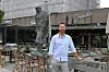 Tom Karp står ved bord og stoler på en uteservering foran en restaurant med statue av Winston Churchill.
