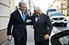 Jonas Gahr Støre og António Costa går sammen utenfor en bygning, med en bil og politibil i bakgrunnen.