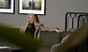 Forbundsleder i Norsk Sykepleierforbund sitter på en sofa i et rom med kunst på veggen.