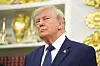 President Donald Trump står i Det ovale kontor foran hyller med trofeer og gullpynt.