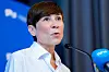 Ine Eriksen Søreide taler ved en mikrofon foran Høyre-bakgrunn og NTB-mikrofon.