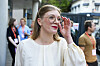 Marie Sneve Martinussen i hvit bluse justerer brillene utenfor partilederdebatten i Arendal.