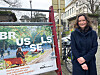 Maria Varteressian står ved en fargerik Brussel-plakat i en bygate.