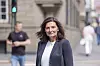 Libe Rieber-Mohn står foran en bygning i Oslo, med fotgjengere og trafikklys i bakgrunnen.