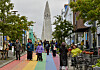 Mennesker i en regnbuefarget gate i Reykjavik, med Hallgrímskirkja synlig i bakgrunnen.