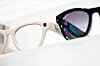 Nærbilde av beige og svarte Ray-Ban Meta-briller i en butikkmonter.