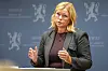 Kjersti Stenseng taler ved en talerstol foran en norsk regjeringsbakgrunn.