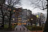 Grønland politistasjon i Oslo sett fra en opplyst gangvei med nakne trær.