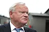 Portrett av skipsreder John Fredriksen i dress utenfor et arrangement i Oslo.