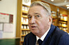 Portrett av Terje Rød-Larsen i mørk dress foran bokhyller på Litteraturhuset i Oslo.