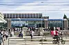 Folk foran Oslo sentralstasjon mens en syklist med matleveringsutstyr passerer.