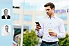 Mann med telefon og kaffekopp foran et moderne kontorbygg.