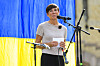 Ine Eriksen Søreide taler ved en mikrofon foran et blågult bakteppe i Oslo.