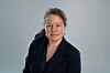 Linn Marie Schilling Tjensvold i Nito med lyst hår i mørk jakke fotografert mot en gråblå bakgrunn.