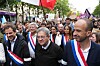 Jean-Luc Mélenchon og Manuel Bompard går i front for en folkemengde med franske flagg i Paris.