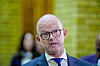 Ole Erik Almlid i dress og briller, fotografert foran en grønn bakgrunn etter finanstalen.