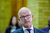 Ole Erik Almlid i dress og briller, fotografert foran en grønn bakgrunn etter finanstalen.