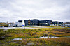 Kirkenes sykehus ligger bak et myrlandskap ved Andrevann under en overskyet himmel.