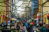 Tett folkeliv i Karl Johans gate i Oslo med julelys og butikker.