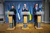 Tre ledere taler fra talerstoler foran norske, ukrainske og finske flagg.