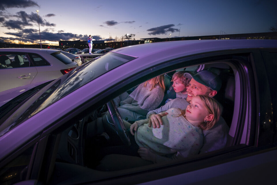 Familien Søgaard fra Ås koser seg i bilen mens Hiphop-gruppa Klovner i Kamp synger for dem og 200 andre biler under Norges første en Drive-Inn konsert på en parkeringsplass i Lillestrøm.